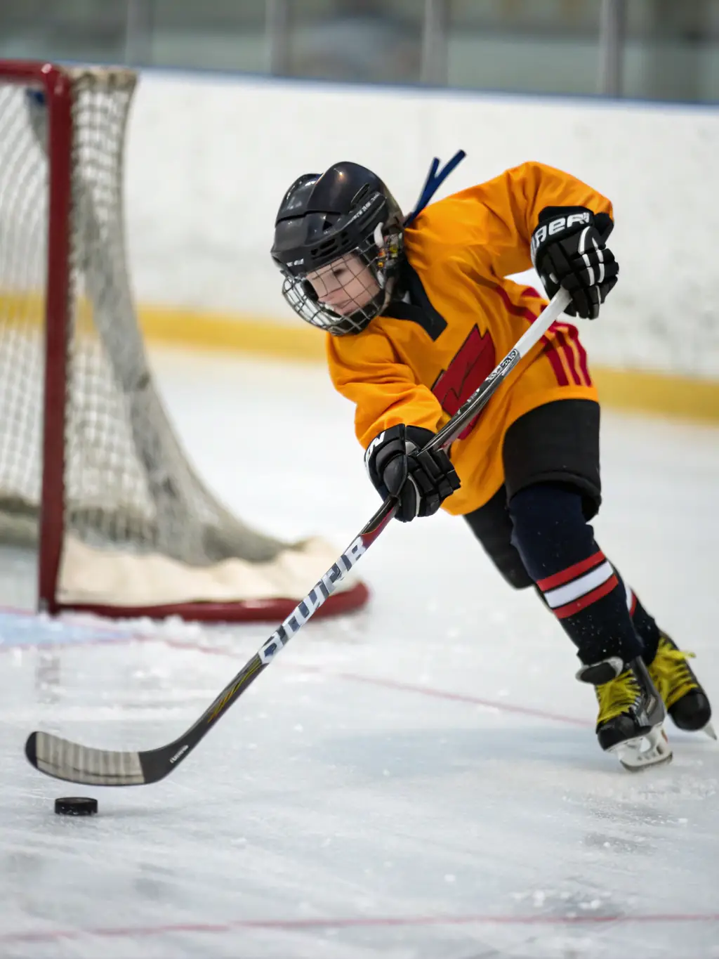 Action shot of DMHC players competing in a hockey match, showcasing their skills and determination on the ice.
