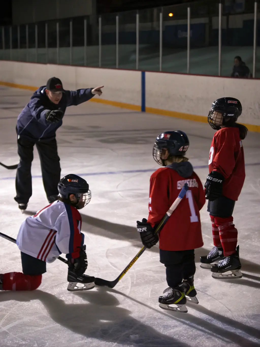 A group of young hockey players in full gear practicing drills on the ice during a training session at the DMHC, focusing on puck control and passing techniques.